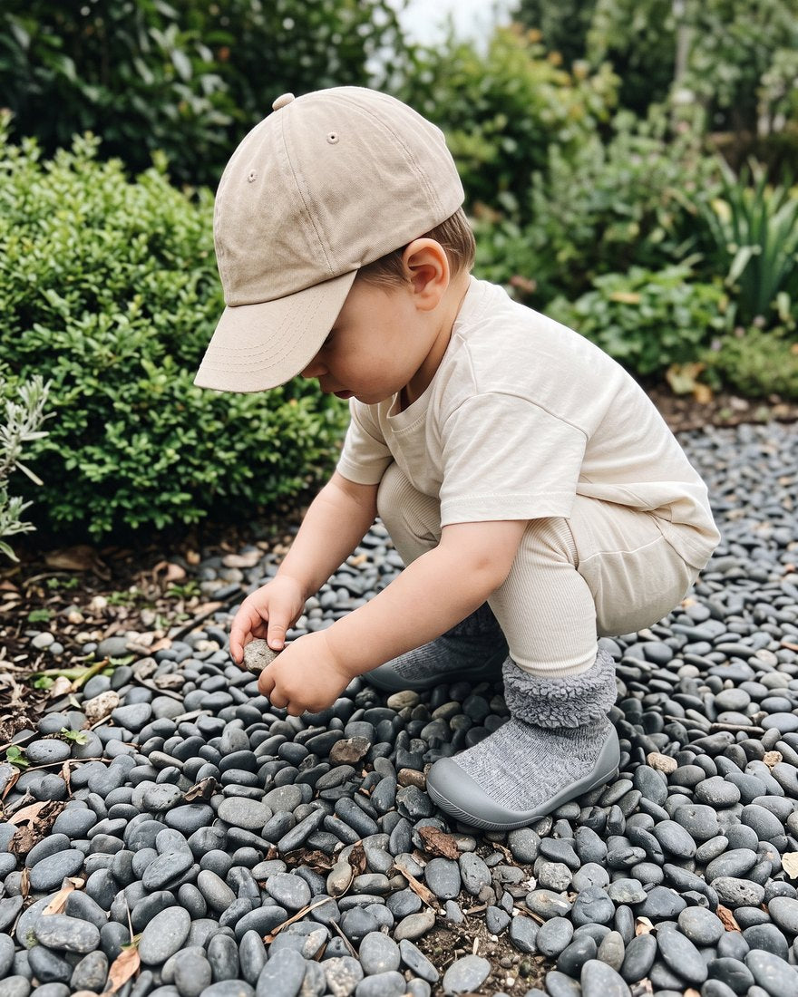 Kleinkind spielt mit Steinen im Garten